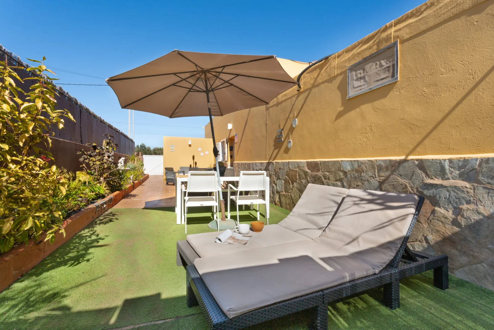 Tumbona bajo una sombrilla en la terraza